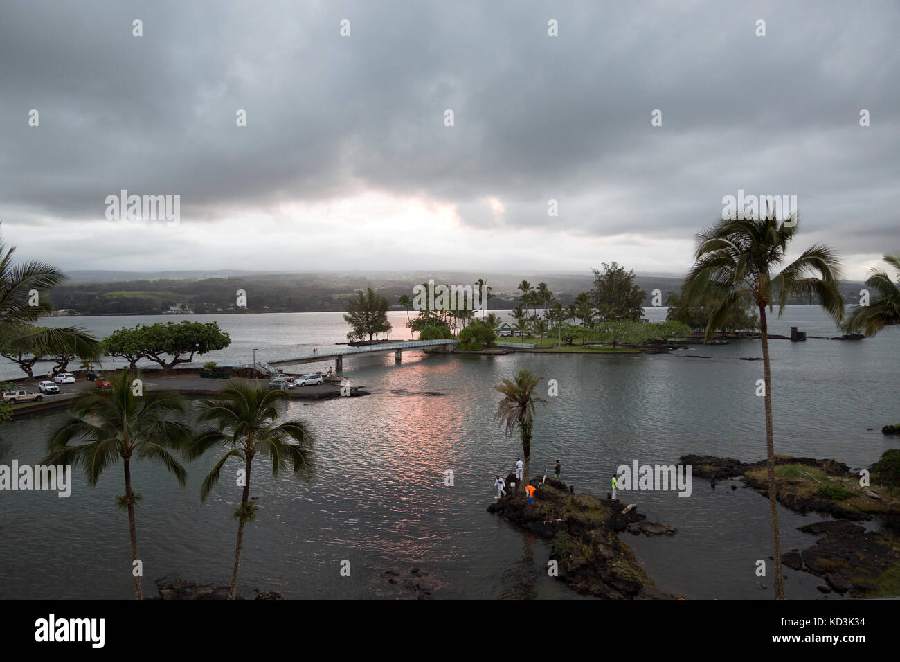 Fishermen fishing the calm waters of Hilo Bay at dusk, with a view of Coconut Island. Stock Photo