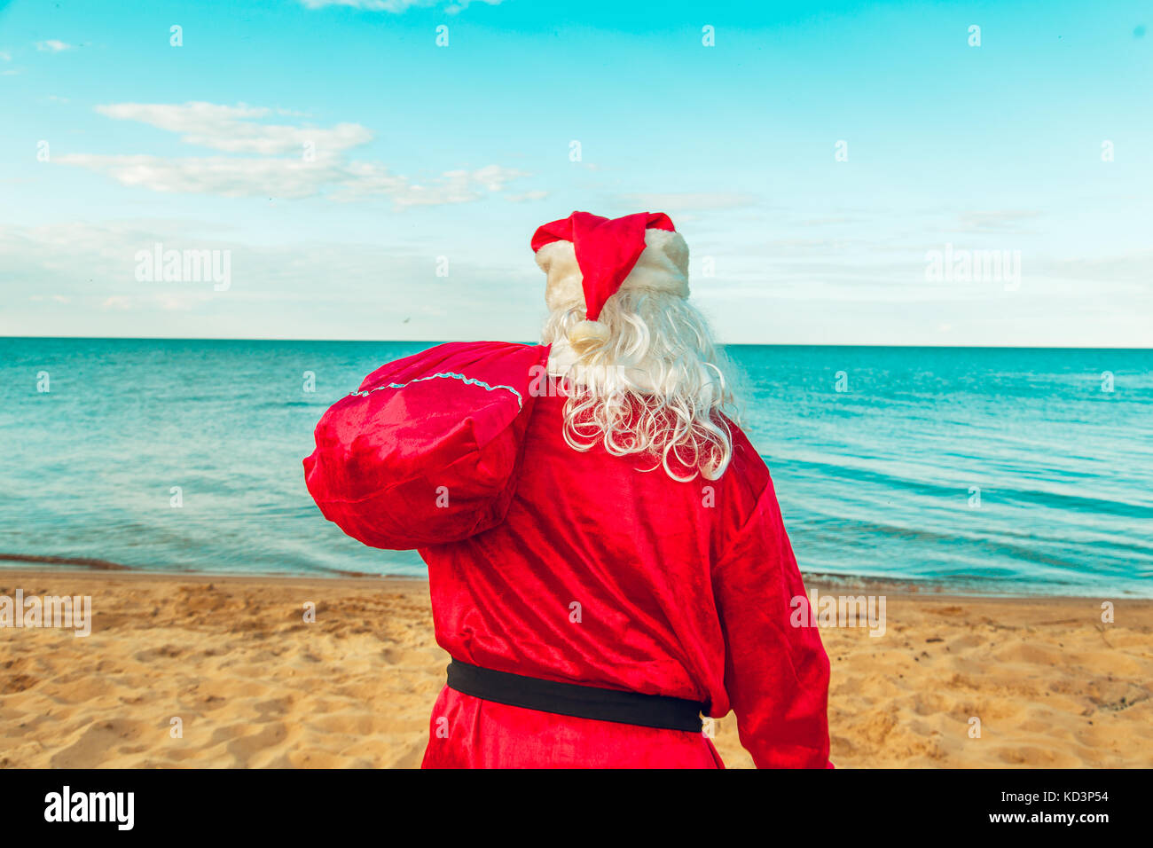 Santa Claus with a bag of gifts on the beach. The symbol of Christmas ...