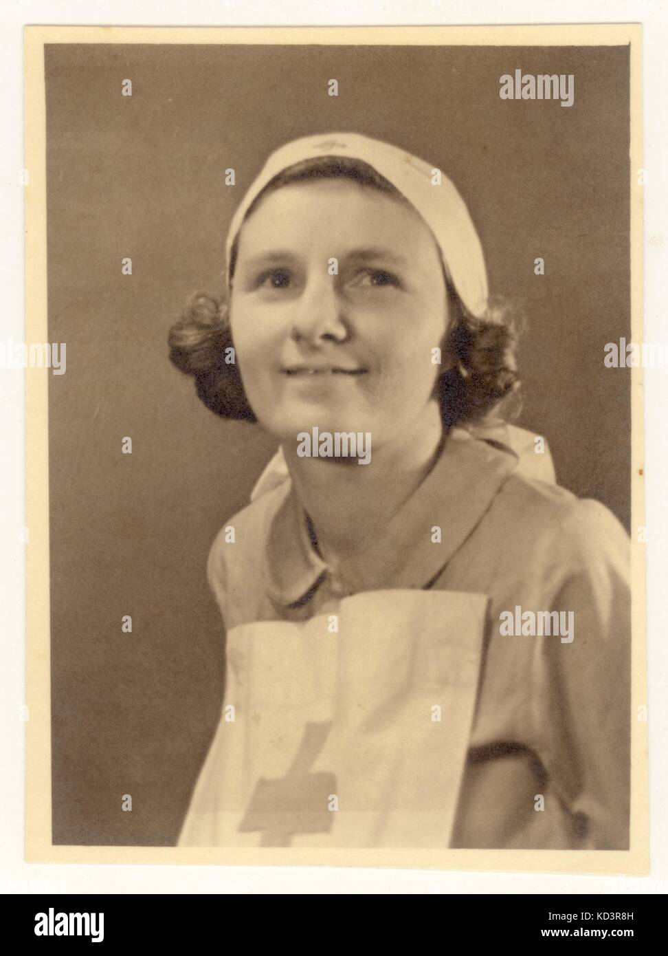Portrait photograph of a caring young Red Cross nurse wearing a Voluntary Aid Detachment (VAD) uniform circa 1940, U.K. Stock Photo