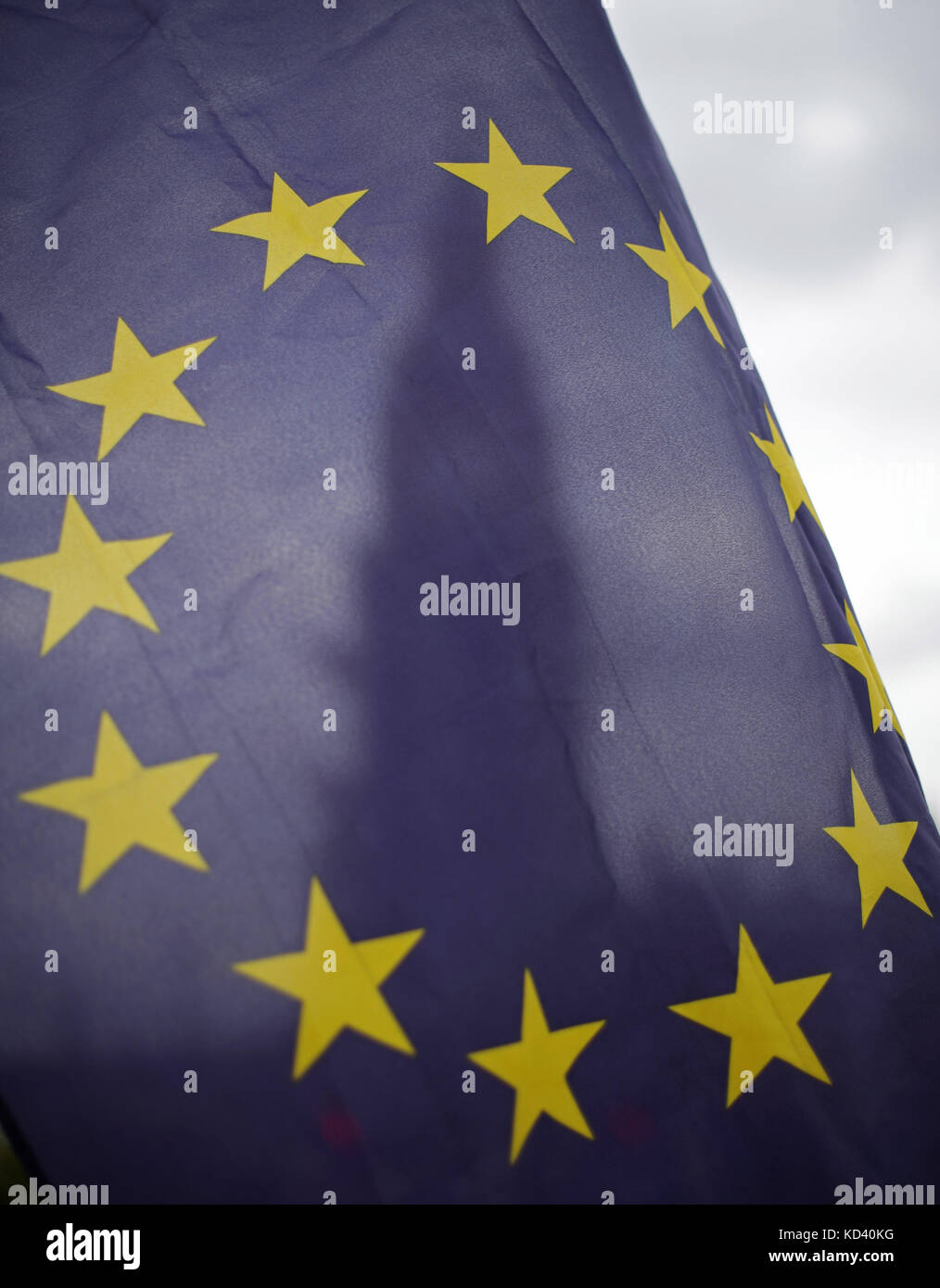 An EU flag is waved in front Big Ben and the Elizabeth Tower at the Houses Parliament in London, after Prime Minister Theresa May updated MPs in the House of Commons, London on the Brexit negotiations since her Florence speech last month. Stock Photo