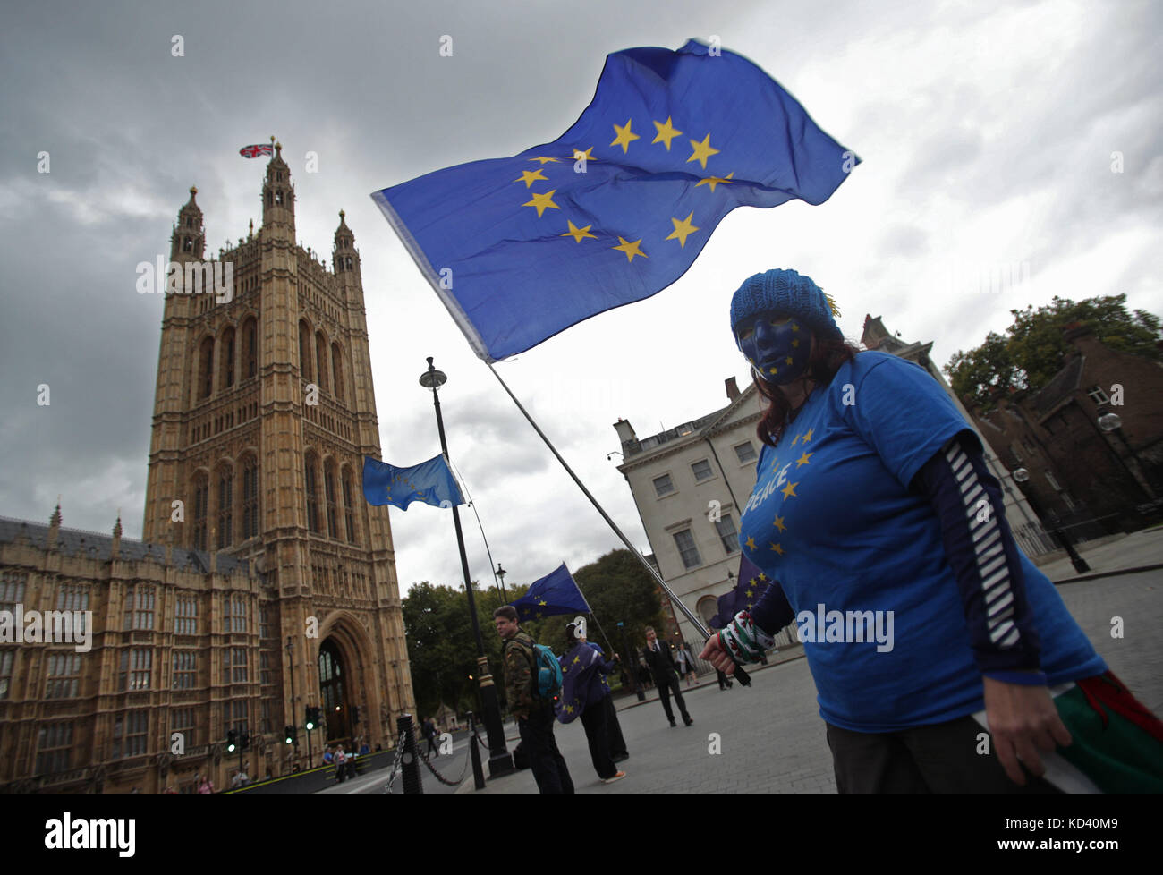 An anti-Brexit protester waves an EU flag outside the Houses of Parliament in London, after Prime Minister Theresa May updated MPs in the House of Commons, London on the Brexit negotiations since her Florence speech last month. Stock Photo
