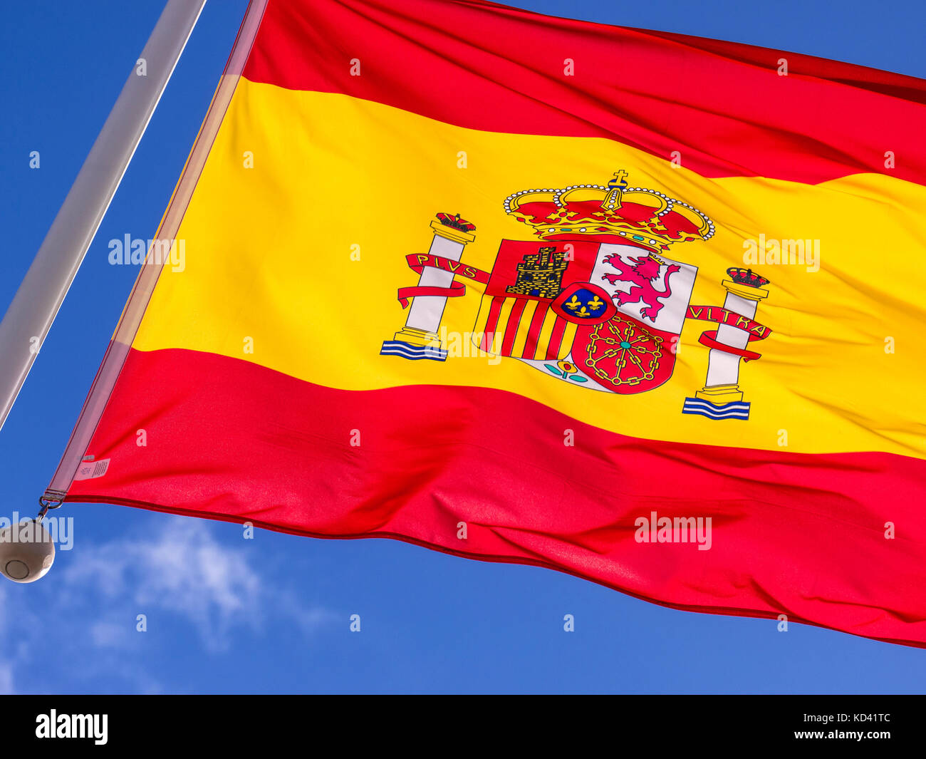 SPANISH FLAG The Flag of Spain ‘Bandera de España’ fluttering in the breeze with typical sunny blue sky behind Stock Photo