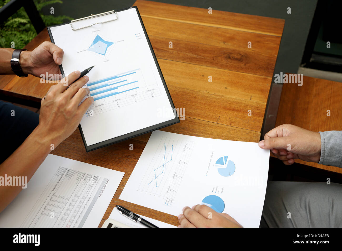 Two businessman working use computer and analysis paper graph on wood table more copy space Stock Photo