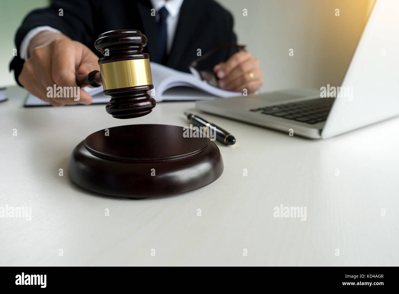 Judge adjudicate in courtroom Referee hammer the gavel on table with laptop notebook. Stock Photo