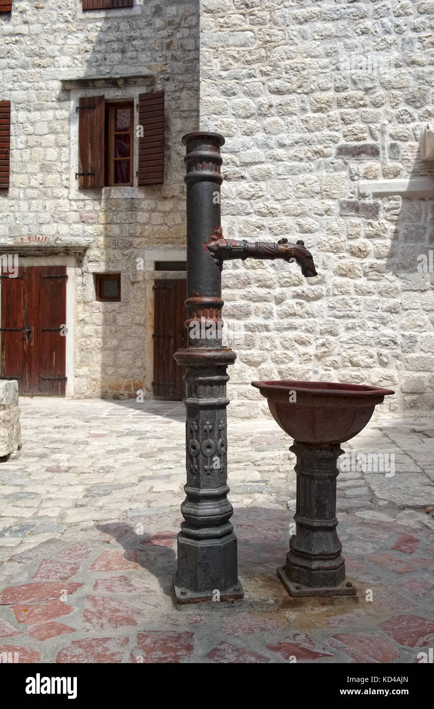 An Water Dispensing Column with a bowl on the street of the old town in Kotor Stock Photo