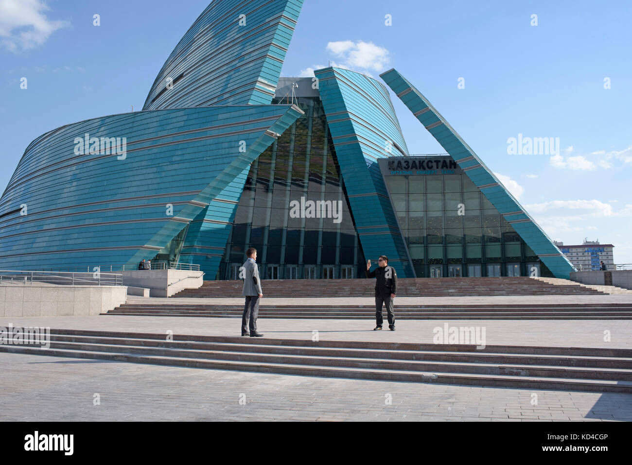 Two men taking a photo in front of the the Kazakhstan Central Concert