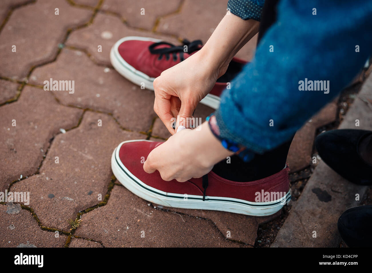 Picture of Woman tying shoelace at park. Casual styled sneakers Stock Photo - Alamy