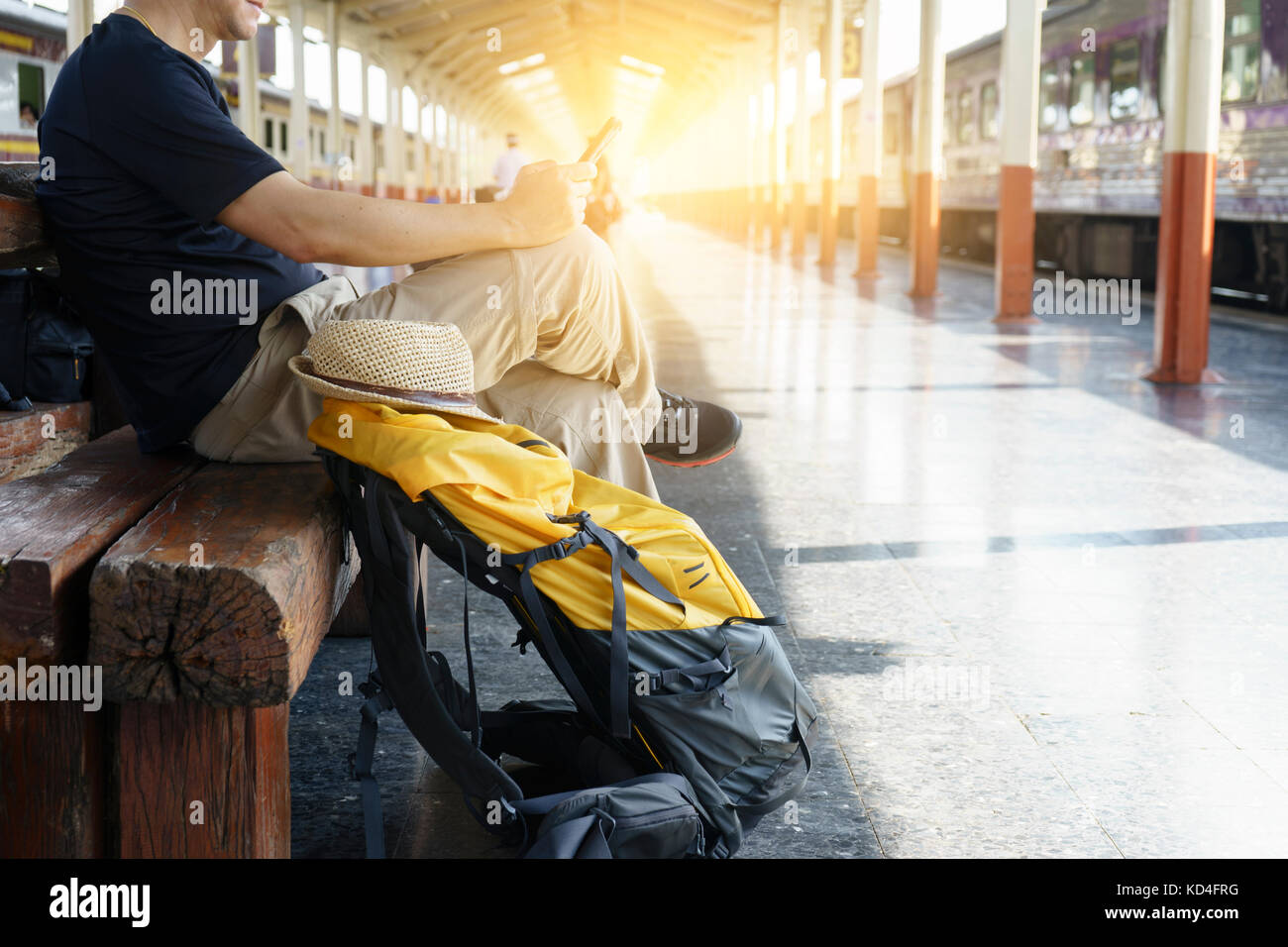 man with her backpack sitting in train station for start his travel program Stock Photo
