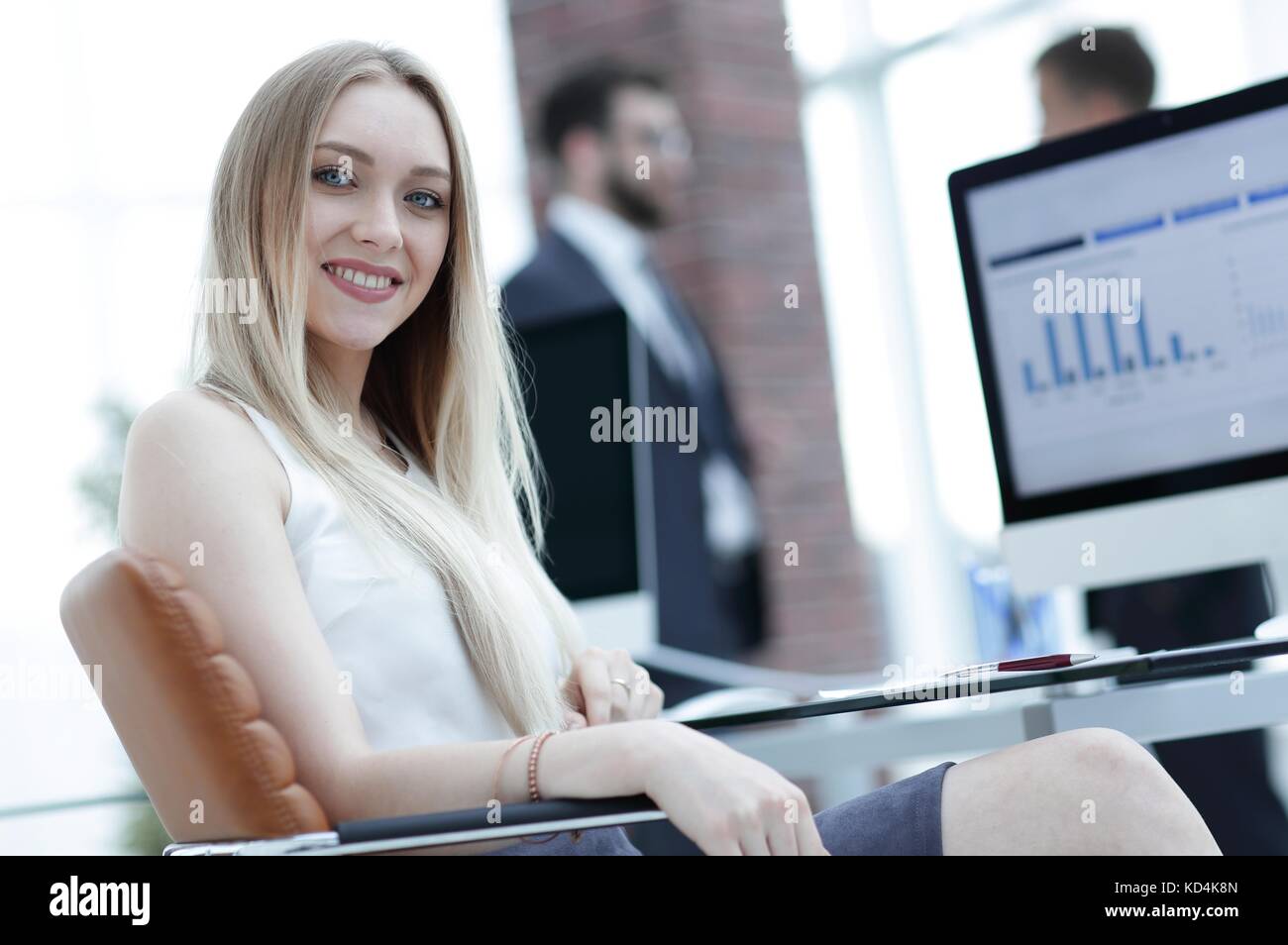 young business woman sitting at a desk in the office Stock Photo - Alamy