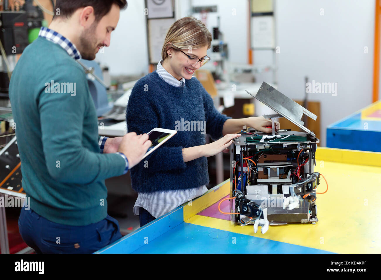 Young students of robotics preparing robot for testing Stock Photo