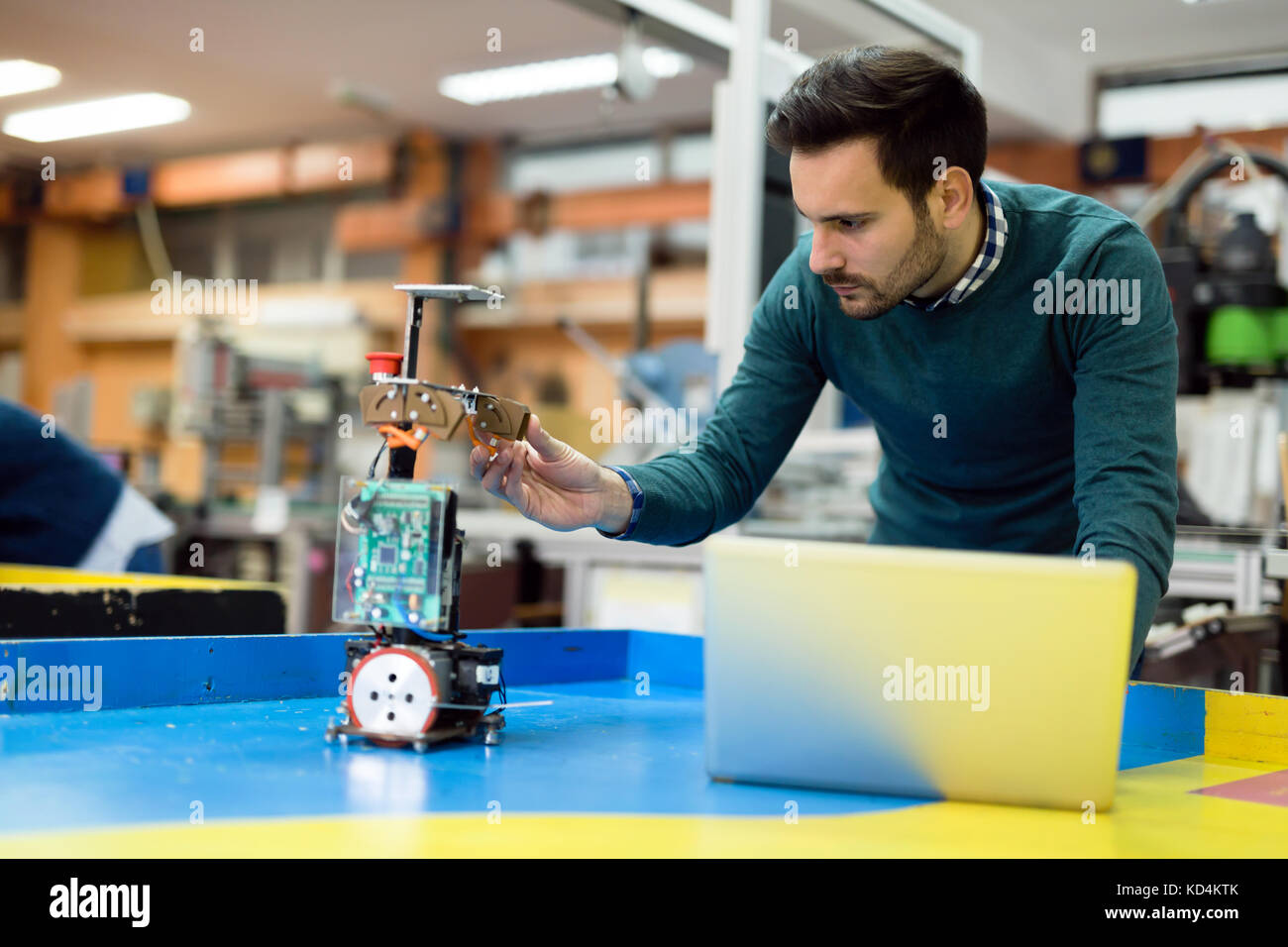 Young engineer testing his robot in workshop Stock Photo - Alamy