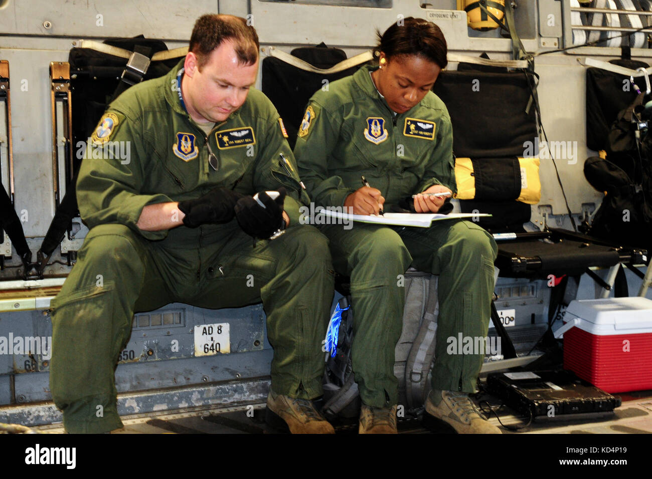 U.S. Air Force Senior Airman Robert Deal and Staff Sgt. Ann Roberts perform calculations for proper restrainment for a 130,000 pound M1 Abram prior to flight. The South Carolina Army National Guard’s 1-118th Combined Arms Battalion (CAB) participates in heavy airlift operations April 10-11, 2014 at Wright Army Airfield (WAAF), Hinesville, Ga., to demonstrate the joint, total force, capabilities of the S.C. Army Guard and U.S. Air Force Reserve’s 315th Airlift Wing.  Soldiers and Airmen worked in unison over two days to load and secure four of the 1-118th CAB’s new M1A1SA Abrams Main Battle Tan Stock Photo
