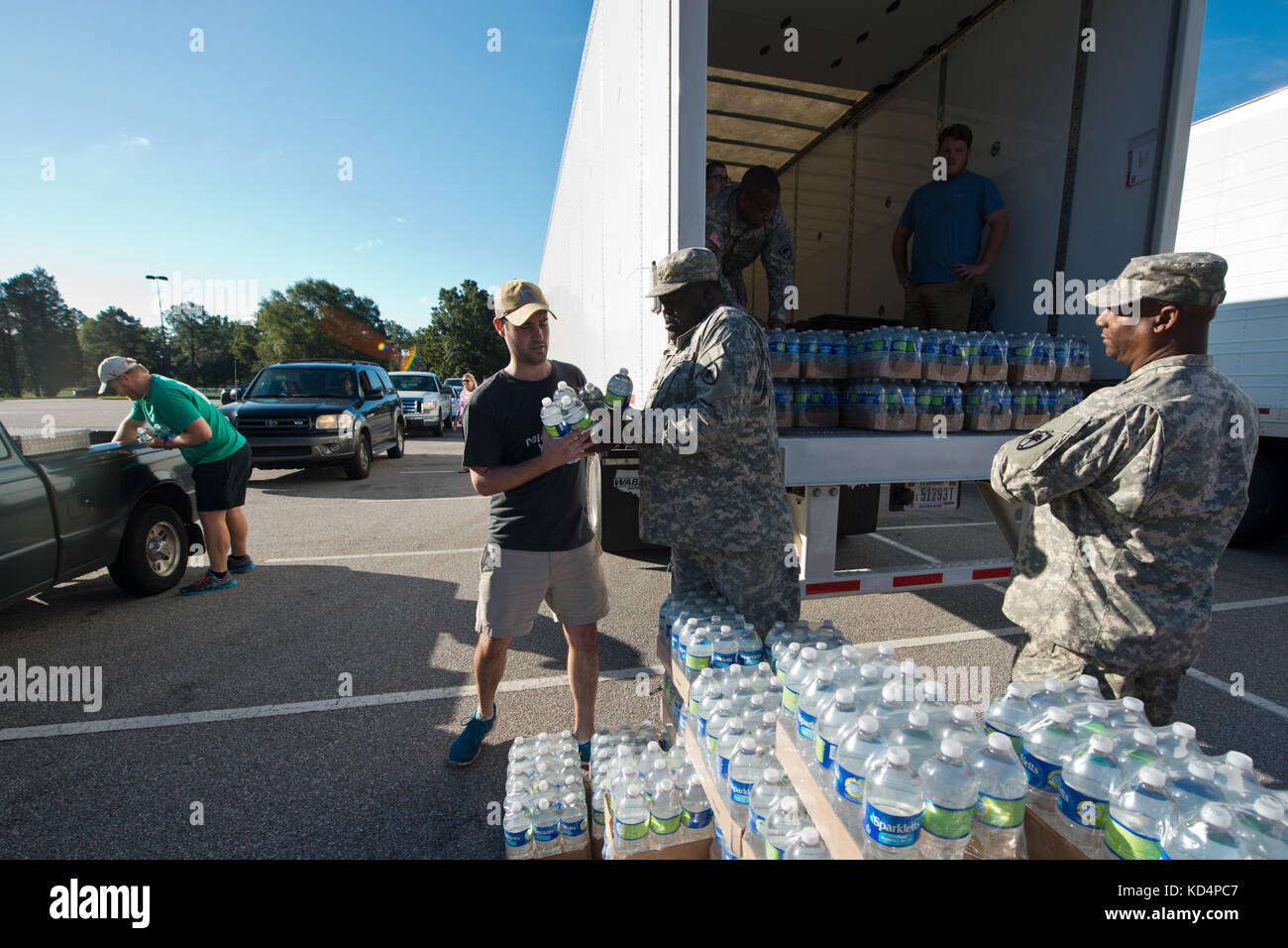 U.S. Soldiers with the 742nd Maintenance Company, South Carolina Army National Guard, work alongside local law enforcement, the State Guard and volunteers, to distribute drinking water to residents affected by  the South Carolina flood at the Lower Richland High School, Columbia, South Carolina, Oct. 6, 2015.  The South Carolina National Guard has been activated to support state and county emergency management agencies and local first responders as historic flooding impacts counties statewide. Currently, more than 1,100 South Carolina National Guard members have been activated in response to t Stock Photo