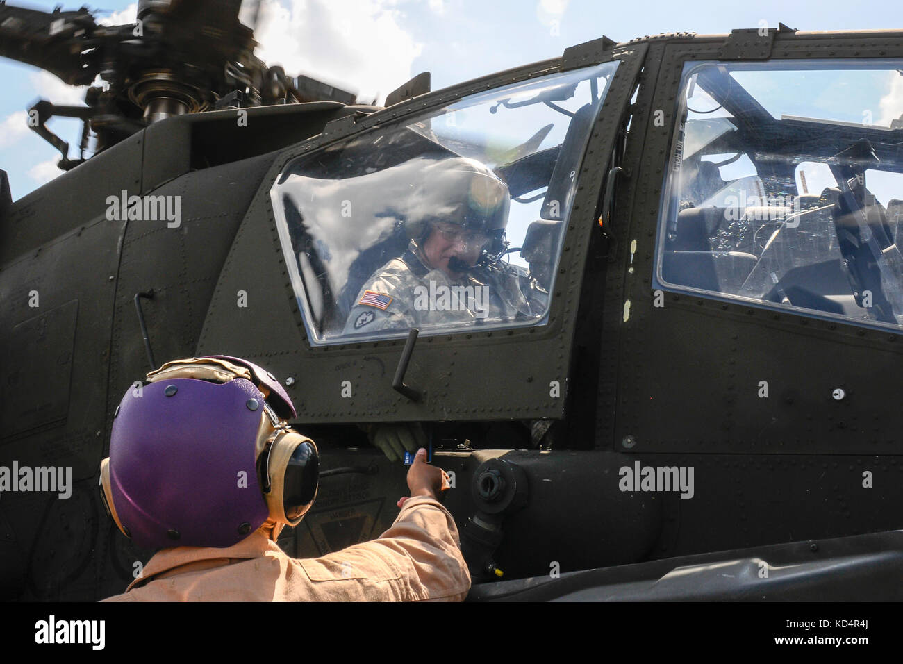 A U.S. Army AH-64 Apache pilot pays for fuel which is provided by U.S. Marines assigned to 273rd Marine Wing Support Squadron, Air Operations Company, during forward air refueling point operations at McEntire Joint National Guard Base, S.C. on May 14, 2014. Elements of the South Carolina Air and Army National Guard and the U.S. Marines conduct joint operations which are crucial to the ongoing success of operational readiness and deployments around the world.  (U.S. Air National Guard photo by Tech Sgt. Jorge Intriago/Released) Stock Photo