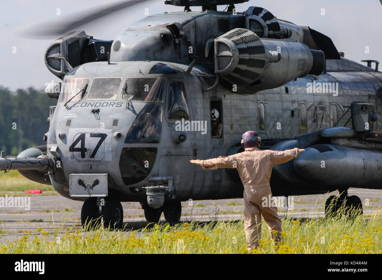 A U.S. Marine assigned to the 273rd Marine Wing Support Squadron, Air Operations Company, marshals a CH-53 Sea Stallion during forward air refueling point operations at McEntire Joint National Guard Base, S.C. on May 14, 2014. Elements of the South Carolina Air and Army National Guard and the U.S. Marines conduct joint operations which are crucial to the ongoing success of operational readiness and deployments around the world.  (U.S. Air National Guard photo by Tech Sgt. Jorge Intriago/Released) Stock Photo
