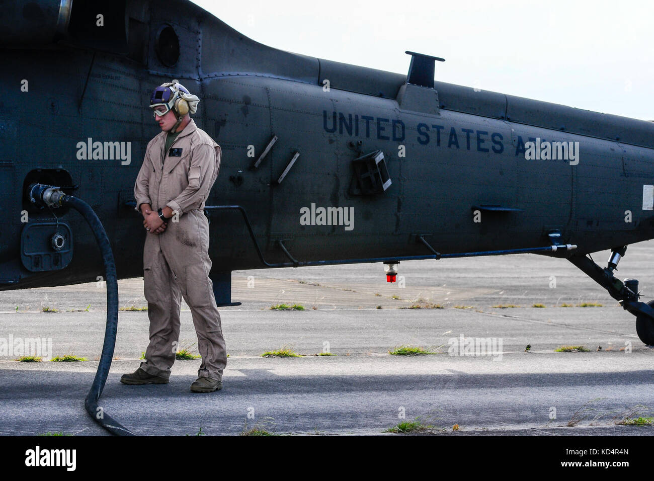 U.S. Marine Cpl. Jason D. Moxley, assigned to the 273rd Marine Wing Support Squadron, Air Operations Company, waits as a UH-60 Blackhawk is fueled during forward air refueling point operations at McEntire Joint National Guard Base, S.C. on May 14, 2014. Elements of the South Carolina Air and Army National Guard and the U.S. Marines conduct joint operations which are crucial to the ongoing success of operational readiness and deployments around the world. (U.S. Air National Guard photo by Tech Sgt. Jorge Intriago/Released) Stock Photo