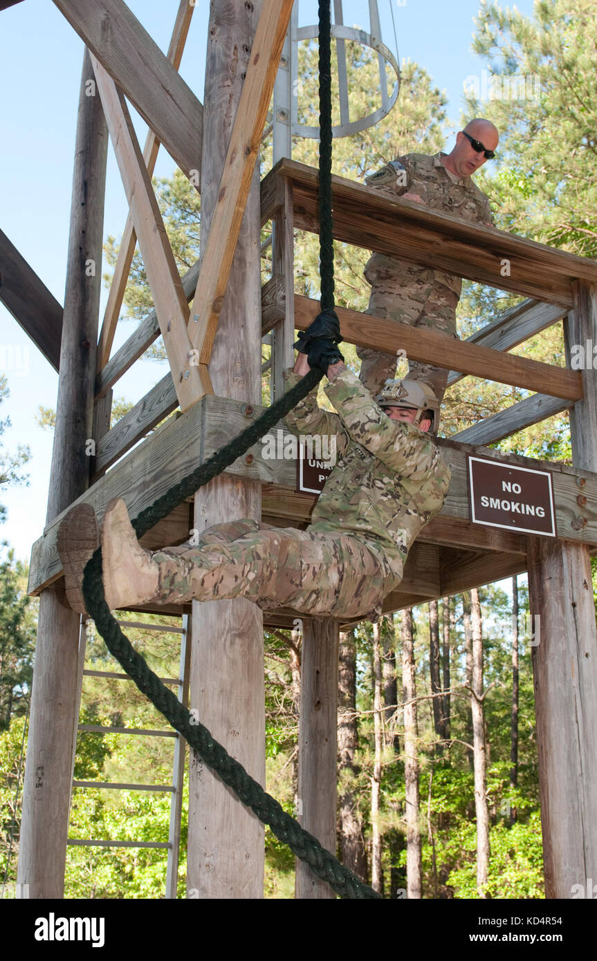 A Soldier from 7th Special Forces Group (Airborne), performs a “lock out” position during a Fast Rope Insertion Exfiltration System (FRIES) demonstration for the 4th Battalion, 118th Infantry Regiment of the South Carolina Army National Guard during their drill weekend at McCrady Training Center, Eastover, S.C., May 17, 2014. Soldiers from 7th Special Forces Group (Airborne), trained approximately 100 Soldiers on the proper FRIES technique over the course of the weekend. (U.S. Army National Guard photo by Sgt. 1st Class Kimberly D. Calkins/Released) Stock Photo