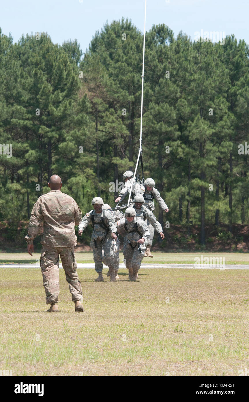 A U.S. Army Soldier assigned to 7th Special Forces Group (Airborne) guides a group of South Carolina Army National Guard Soldiers assigned to 4th Battalion, 118th Infantry Regiment, during Special Insertion Exfiltration System (SPIES) training at McCrady Training Center, Eastover, S.C., May 17, 2014. The Soldiers landed safely to the ground by a Chinook provided by the 160th Special Operations Aviation Regiment (Airborne). (U.S. Army National Guard photo by Sgt. 1st Class Kimberly D. Calkins/Released) Stock Photo
