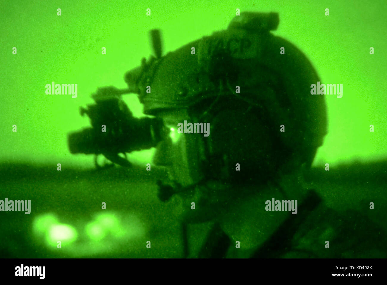 A U.S. Air Force Joint Terminal Attack Controller assigned to the 22nd Special Tactics Squadron looks through his night vision as he conducts close air support operations at Poinsett Electronic Combat Range on Shaw Air Force Base, S.C., May 21, 2014.  Elements of the South Carolina Army and Air National Guard, U.S. Army and U.S. Air Force special operations, and Columbia Police Department S.W.A.T., conducted nighttime training, which allowed special operations forces and the National Guard to conduct joint urban assault training. (U.S. Army National Guard photo by Sgt. Brian Calhoun/Released) Stock Photo