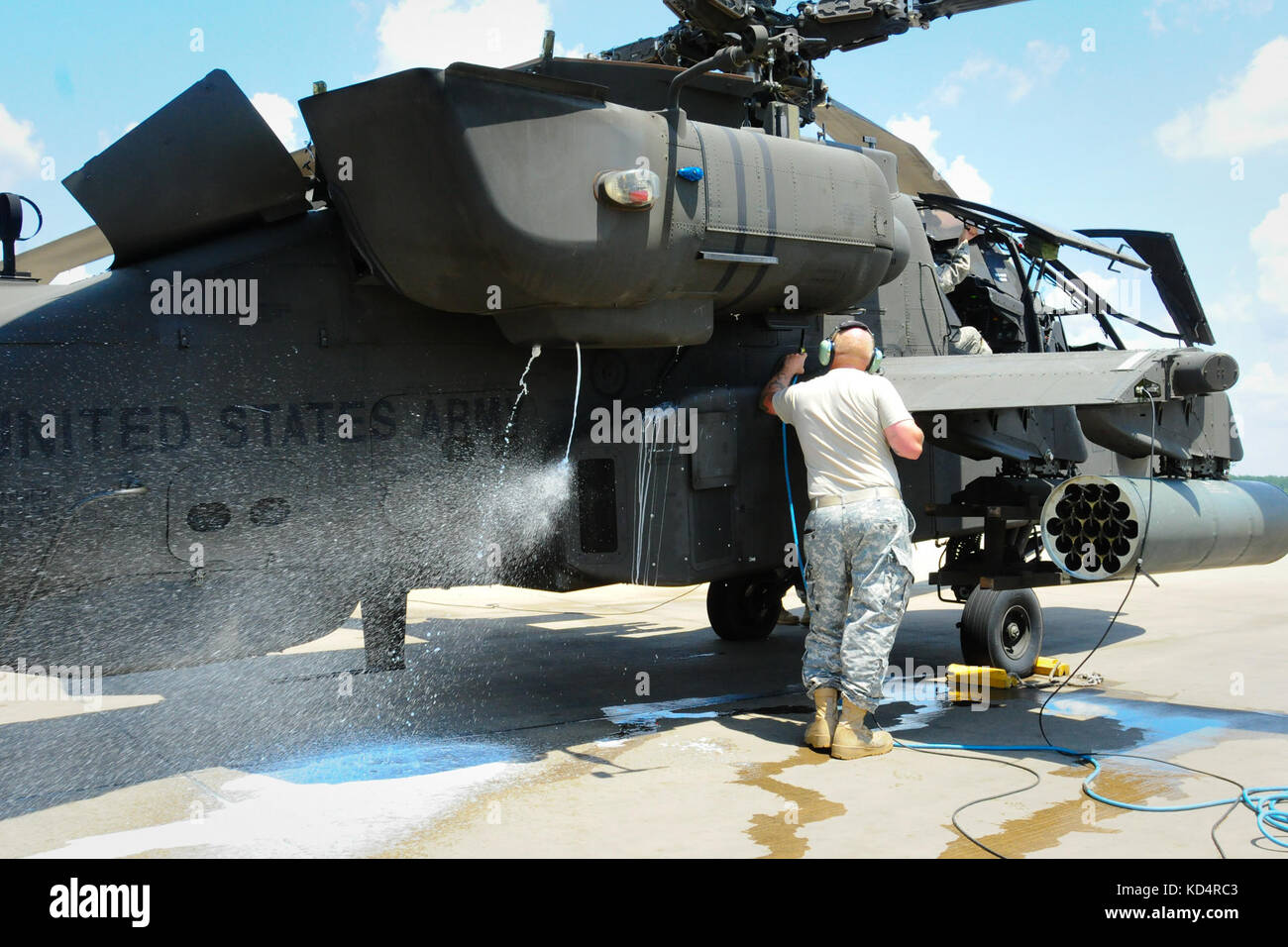 Soldiers from the 1-151 Attack Reconnaissance Battalion, South Carolina Army National Guard, perform preventative maintenance on a U.S. Army AH-64D Apache by washing the aircraft’s turbines engines at McEntire Joint National Guard Base on July 12, 2014. A sprayer-nozzle attached to the gas turbine engine injects hot soapy water into the engines to remove debris and carbon build-up. (U.S. Army National Guard photo by Brian Calhoun/Released) Stock Photo