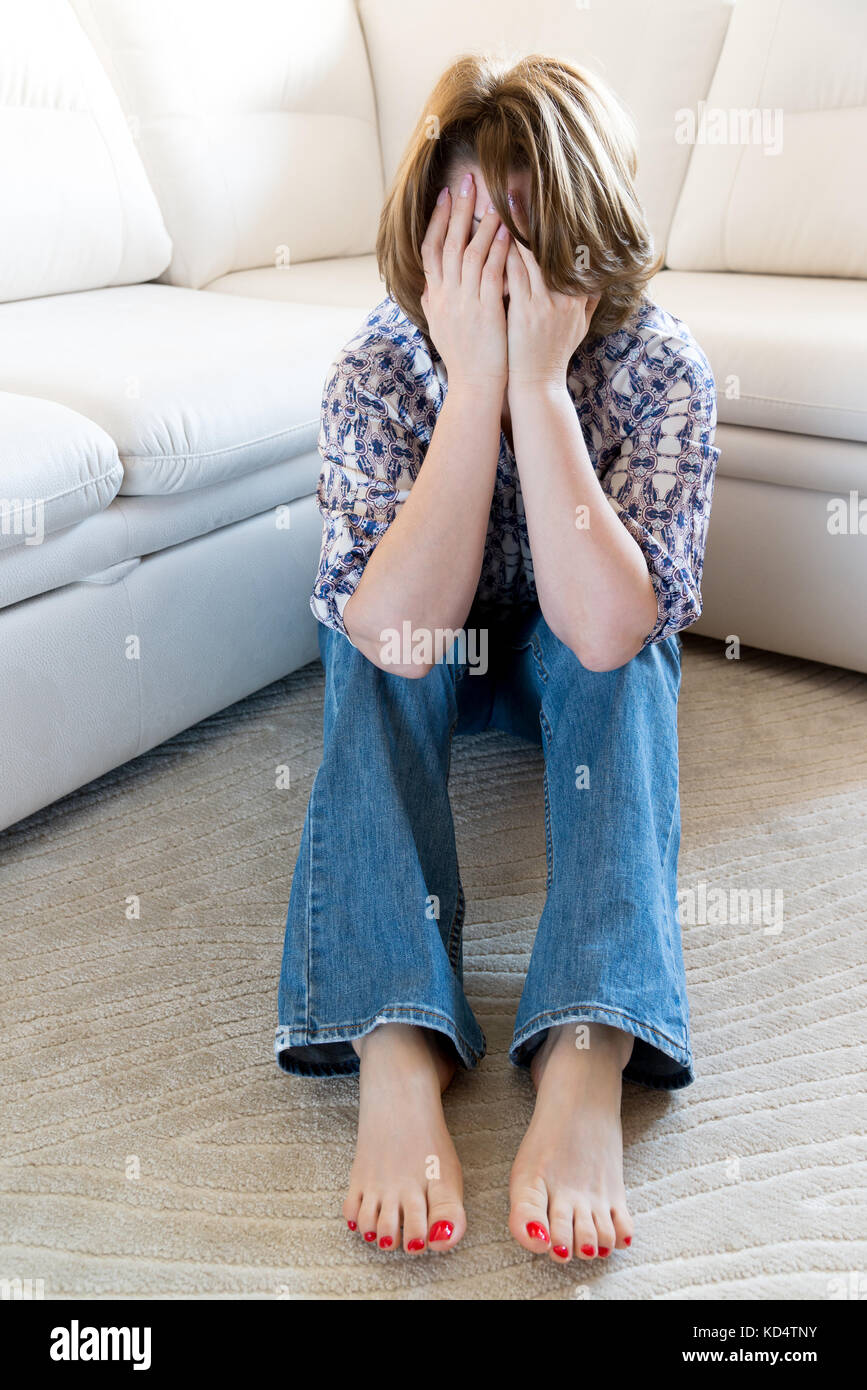Woman in stress covered her face with her hands Stock Photo