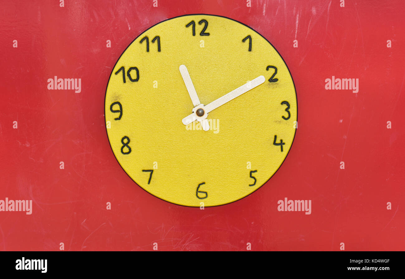 Wooden big yellow clock in children playground. Time abstraction Stock