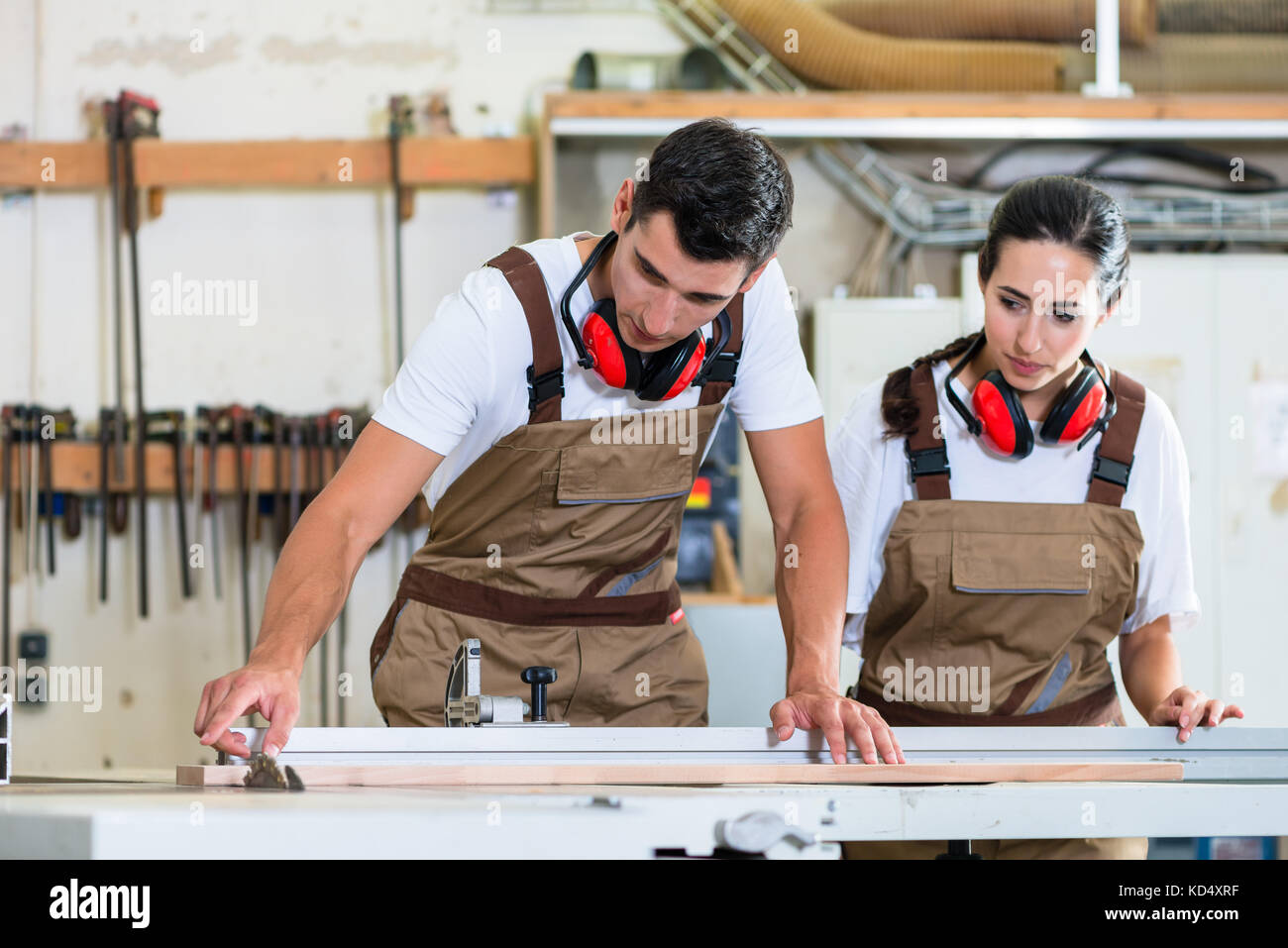 Carpenter and apprentice working together in workshop Stock Photo