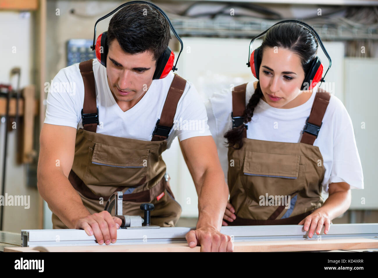 Carpenter and apprentice working together in workshop Stock Photo