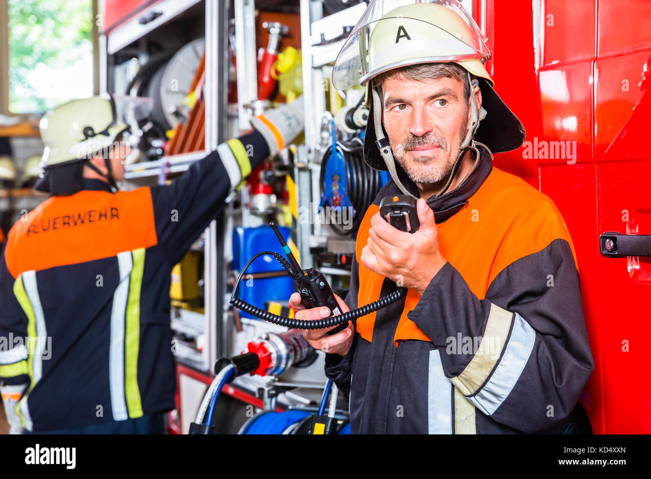 Chief fire fighter  checking radio set Stock Photo
