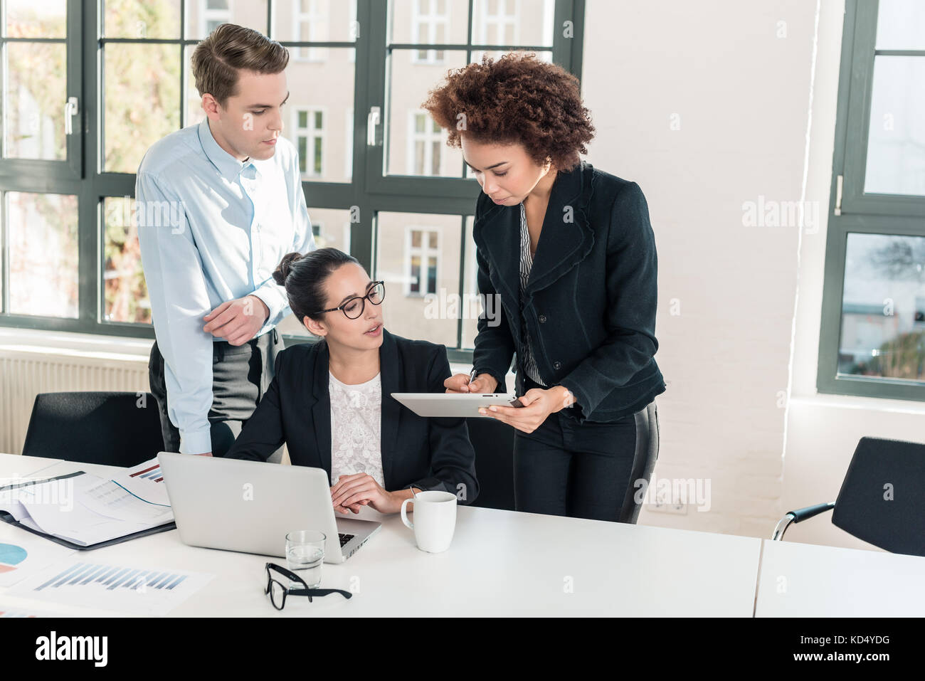 Three members of a young professional team working together Stock Photo
