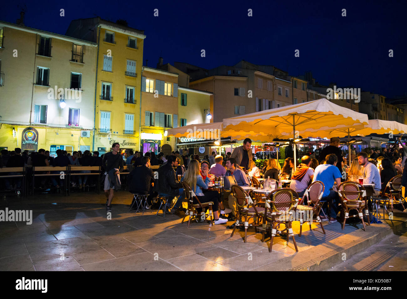 Lively night-time atmosphere and people at restaurants at Place des Cardeurs, Aix en Provence, France Stock Photo