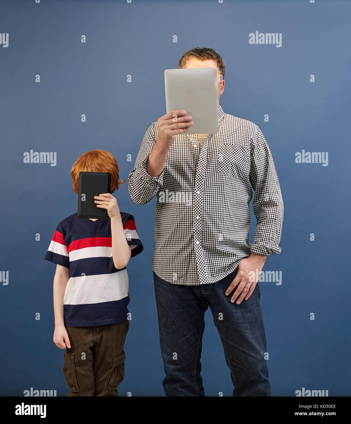 adult and child looking at tablets Stock Photo