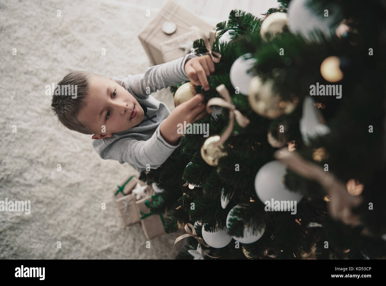 Boy decorating a christmas tree Stock Photo Alamy