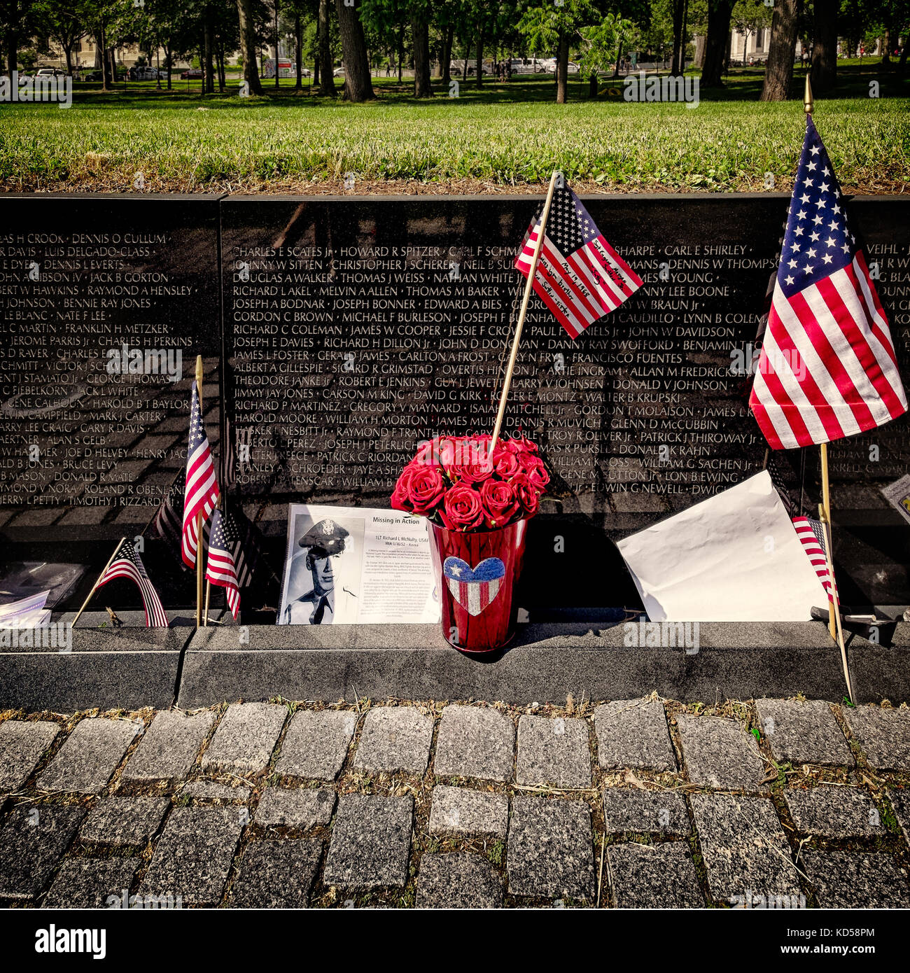WASHINGTON DC-May 25, 2015: Vietnam Memorial viewed below ground level, with flags, messages and a pot of roses left on Memorial Day. Square Stock Photo
