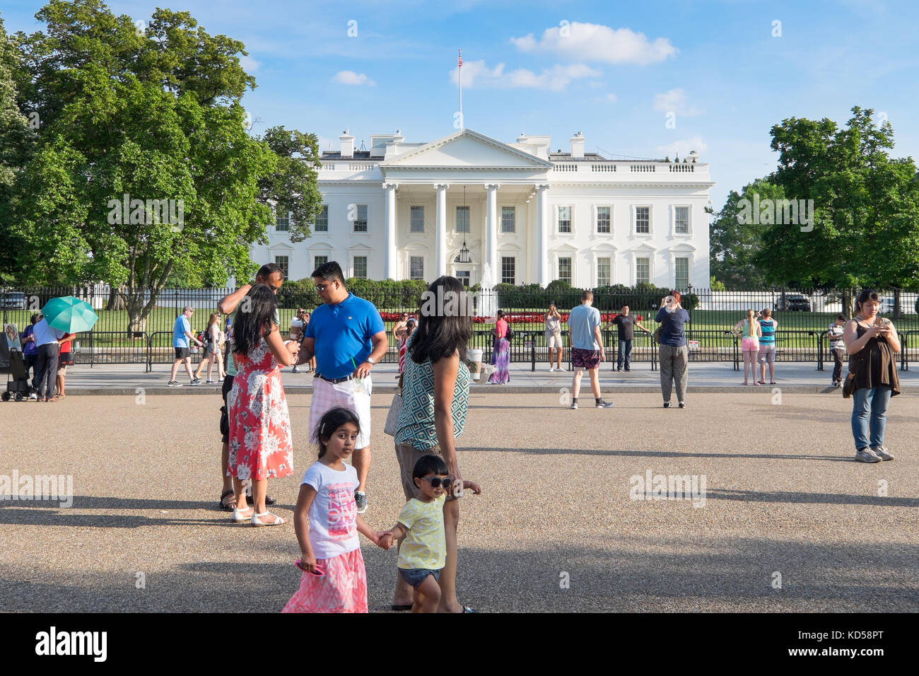 WASHINGTON DC-May 26, 2015: Whitehouse viewed from the front on a summer day with blue sky and puffy white clouds. Visitors wander around on the pedes Stock Photo
