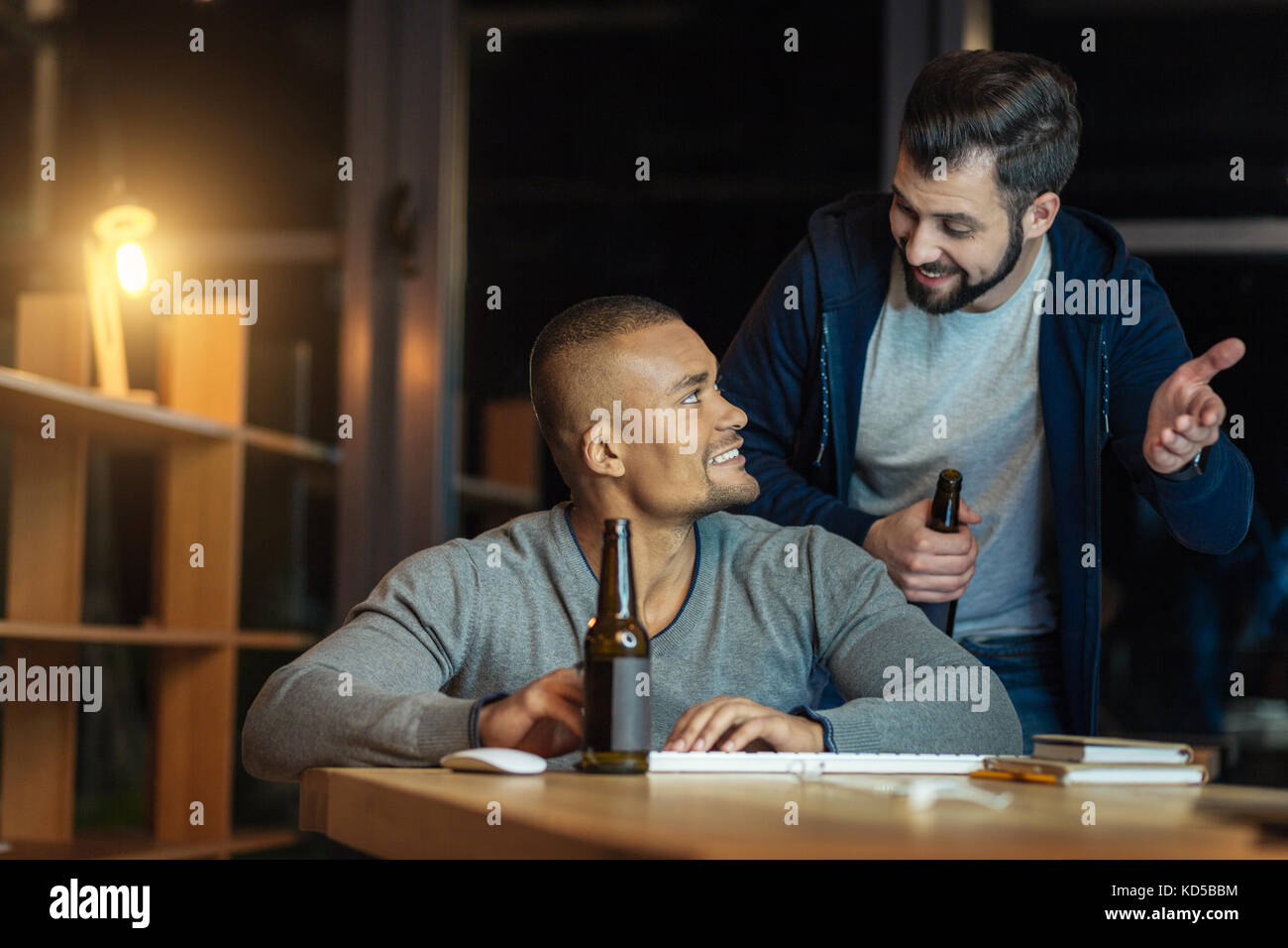 Competent programmer listening to his colleague Stock Photo