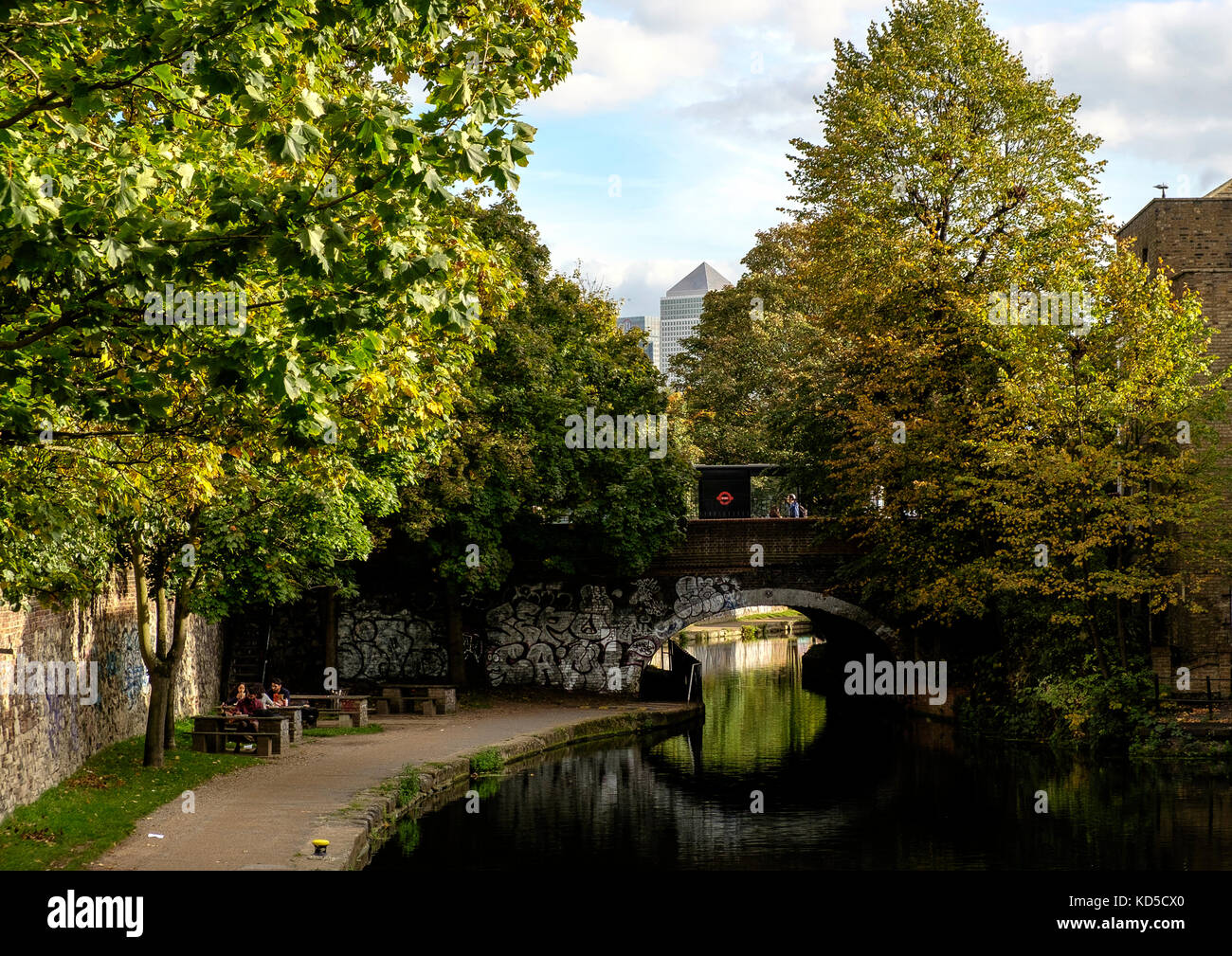 Looking towards Canary Wharf from Mile End Lock on the Regents Canal, London. The bridge carries the A11, Mile End Road. Stock Photo
