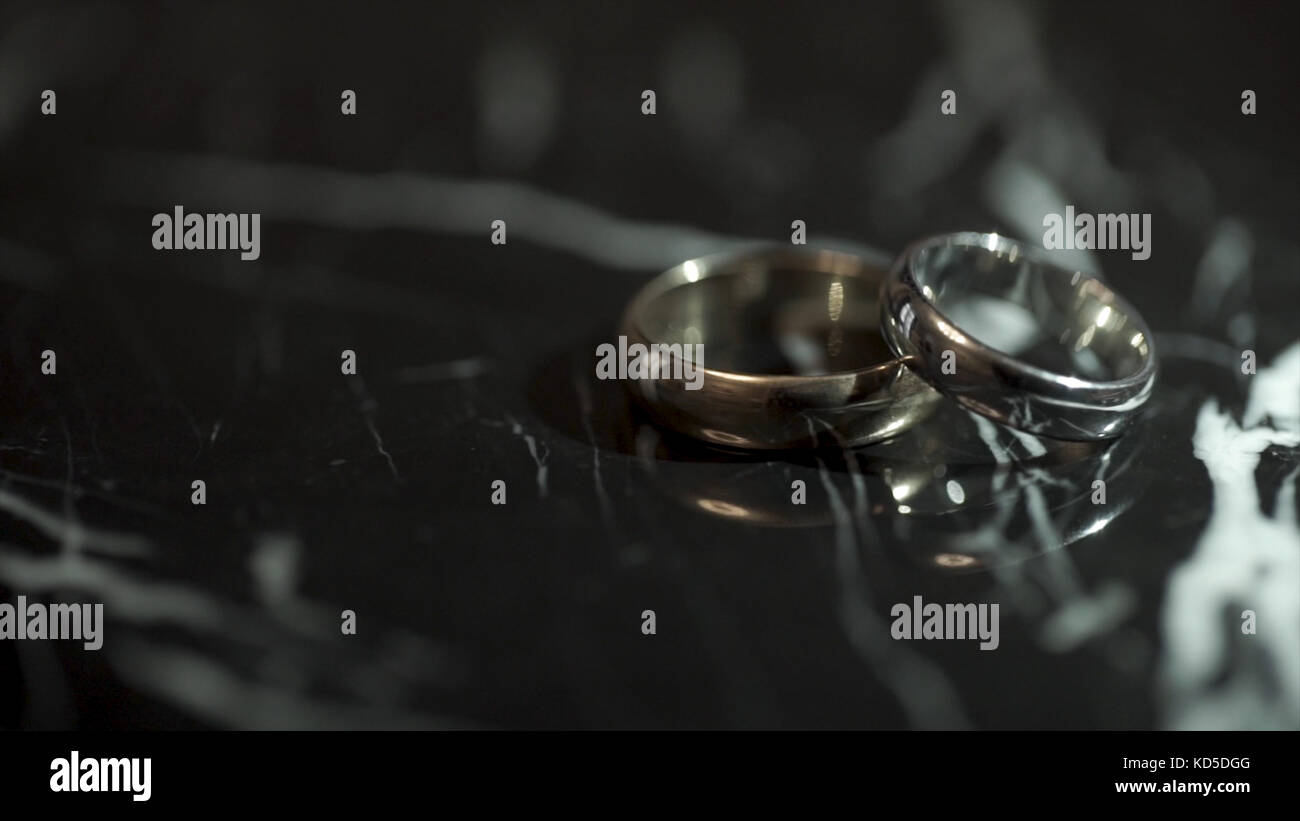 Wedding rings on a black marble stone table. Two rings on a black