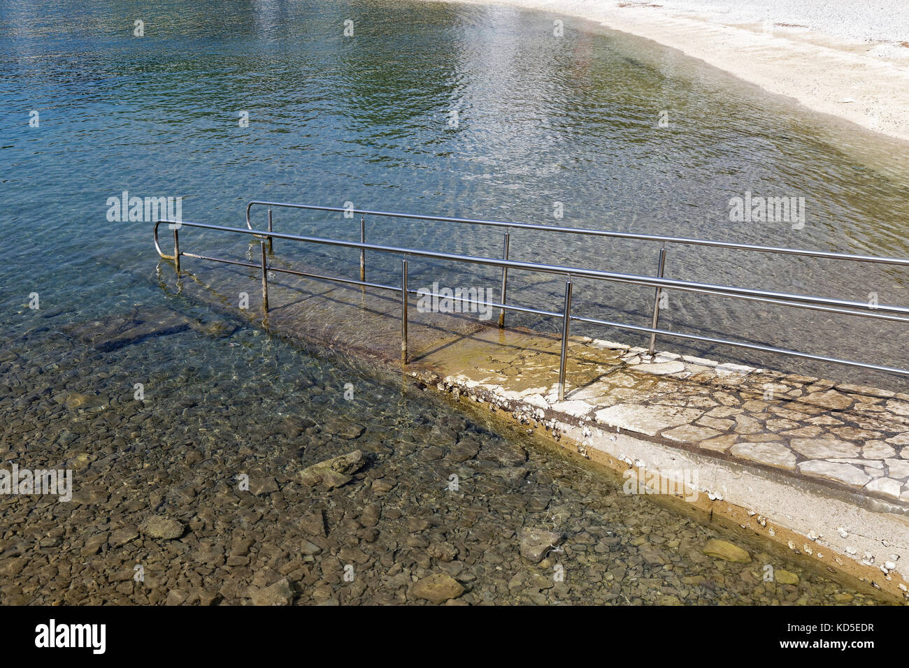 paved sea ramp with metal handrail, side view Stock Photo