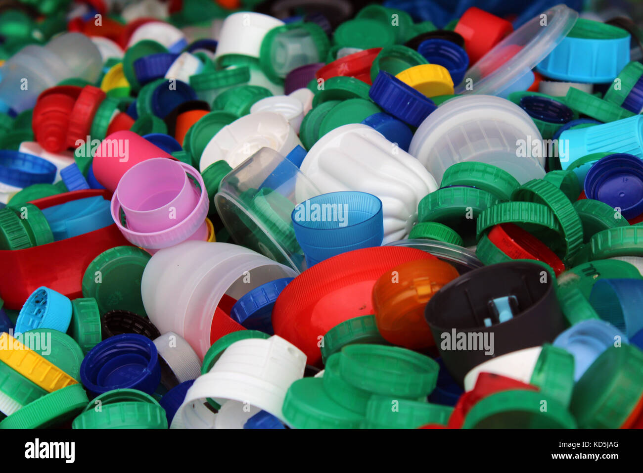Plenty of colorful plastic bottles tops ready to be recycled (save the environment from plastic and recycle reuse go green themes) Stock Photo
