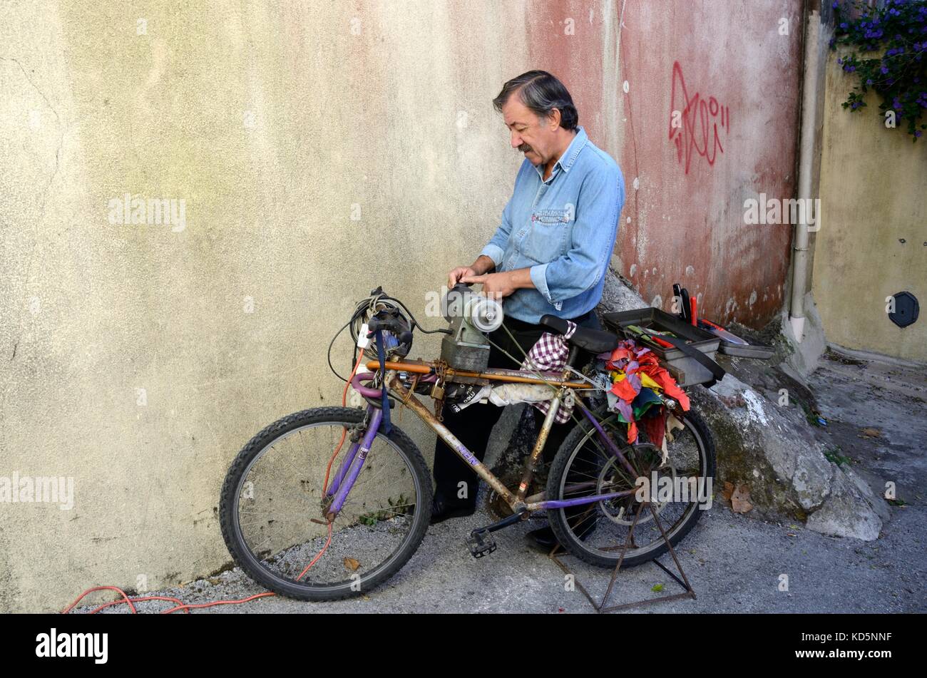 man sharpening knives and scissors from his bike bicycle Sintra Portugal Stock Photo