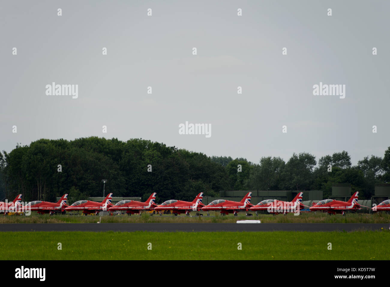 The planes of The Royal Air Force Aerobatic Team (Red Arrows) are arranged beside the runway at military airbase in Leeuwarden. Stock Photo