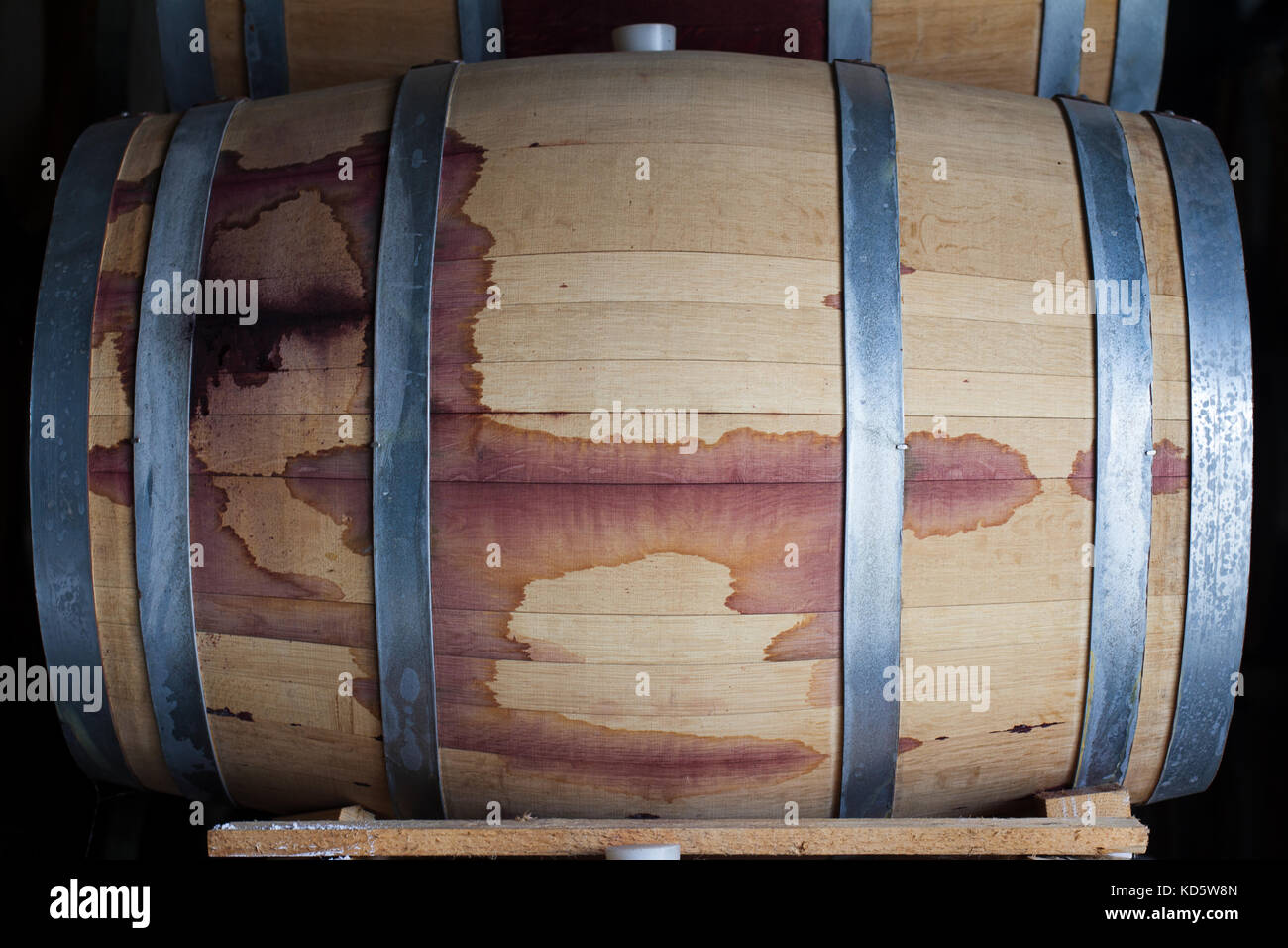 front view closeup of a wine oak wood barrel stained with red Stock Photo