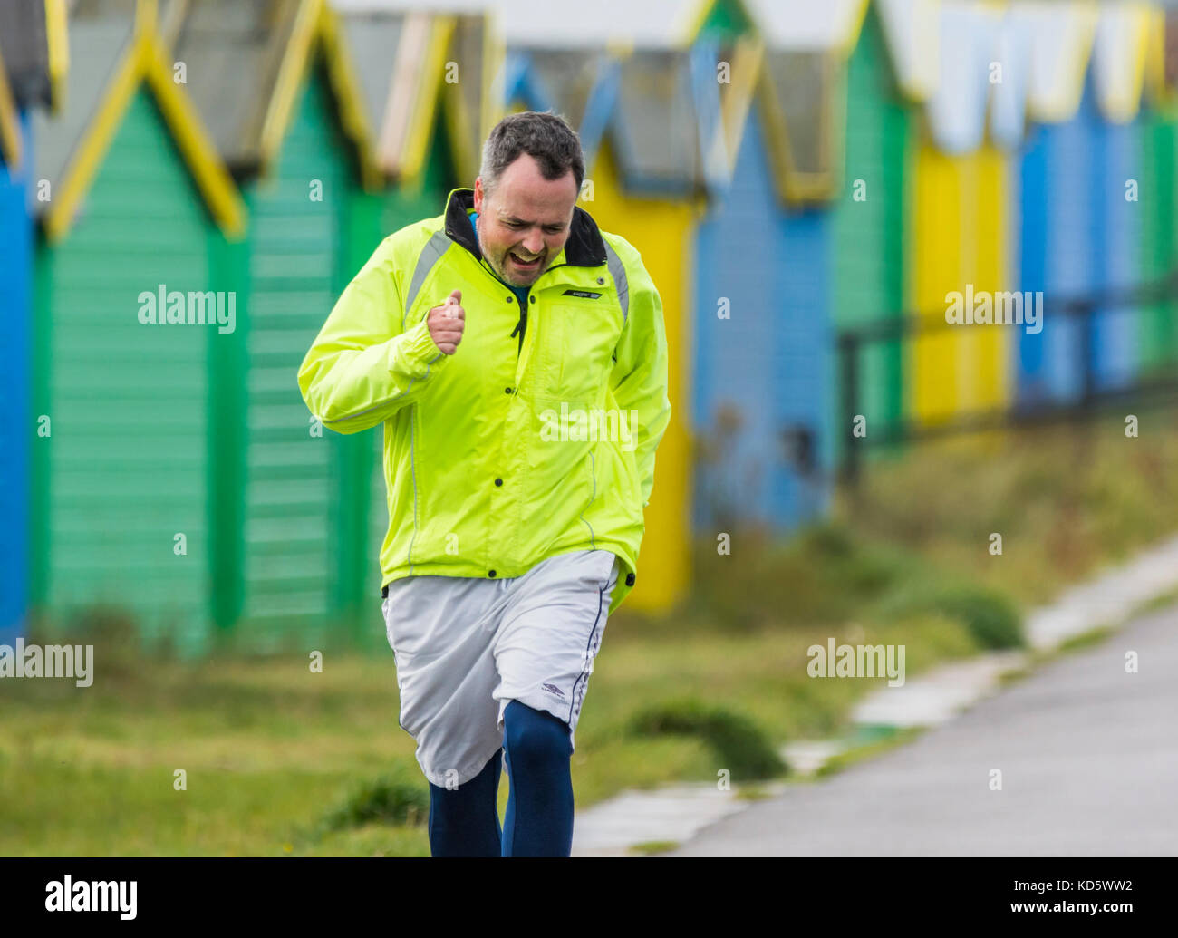 Man having a morning jog with a straining facial expression. Stock Photo