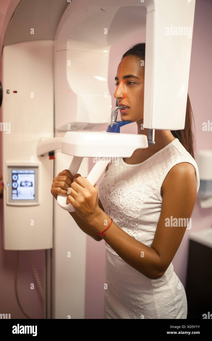 Young woman doing xray of teeth on xray machine in dental office
