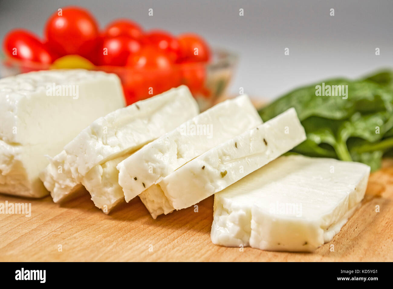 Fresh sliced halloumi cheese from Cyprus on a wooden board surface Stock Photo