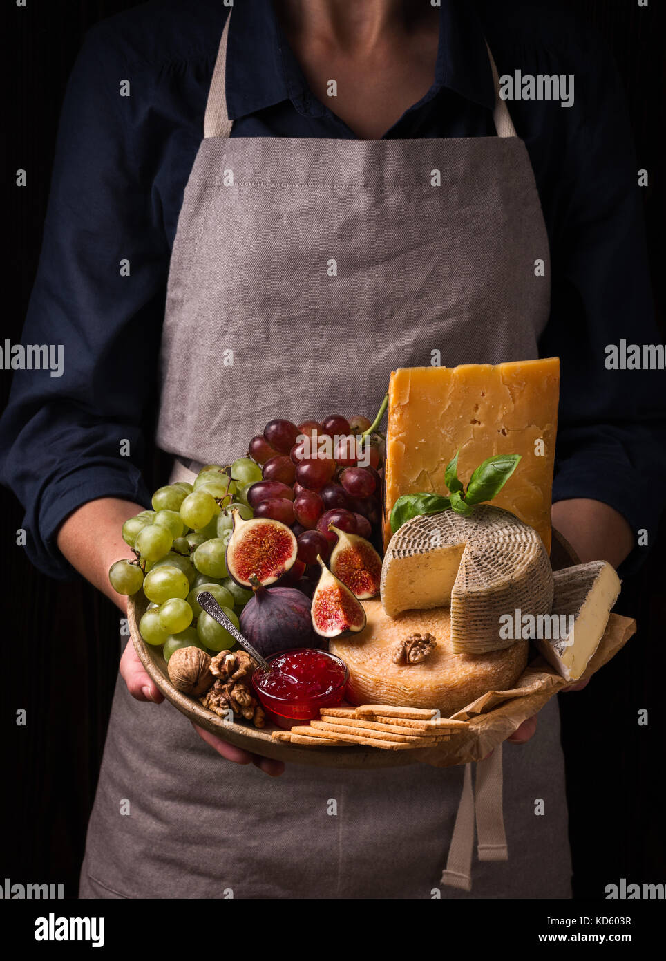 Woman holding a cheese plate with fruits and jam Stock Photo Alamy