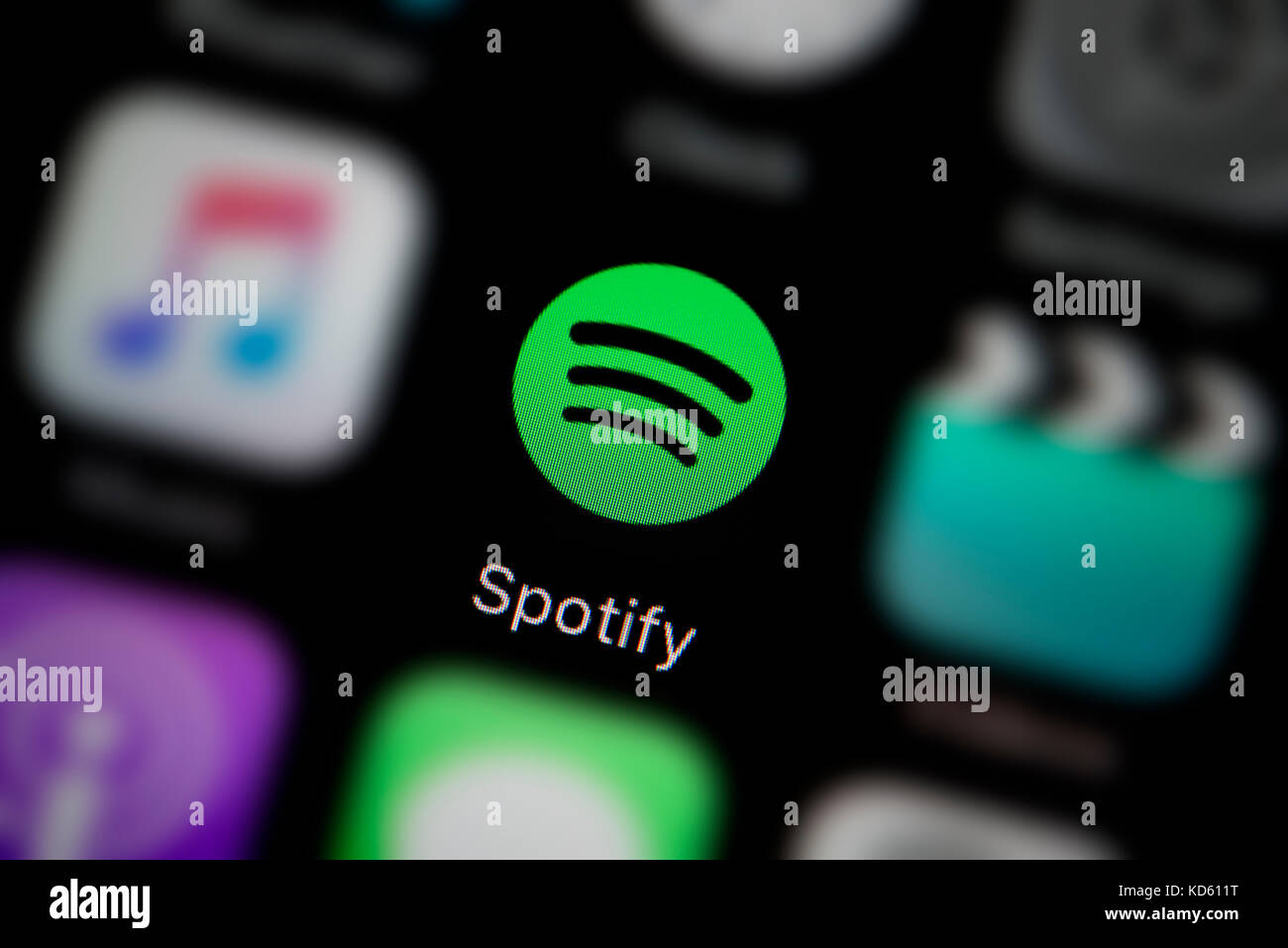 A close-up shot of the company logo representing the Spotify app icon, as seen on the screen of a smart phone (Editorial use only) Stock Photo