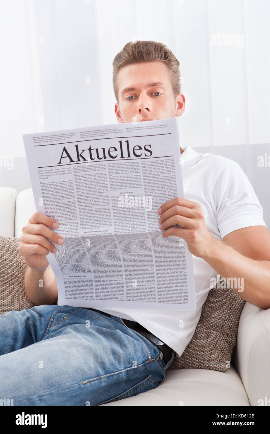 Man Reading Newspaper With The Headline Current News Stock Photo