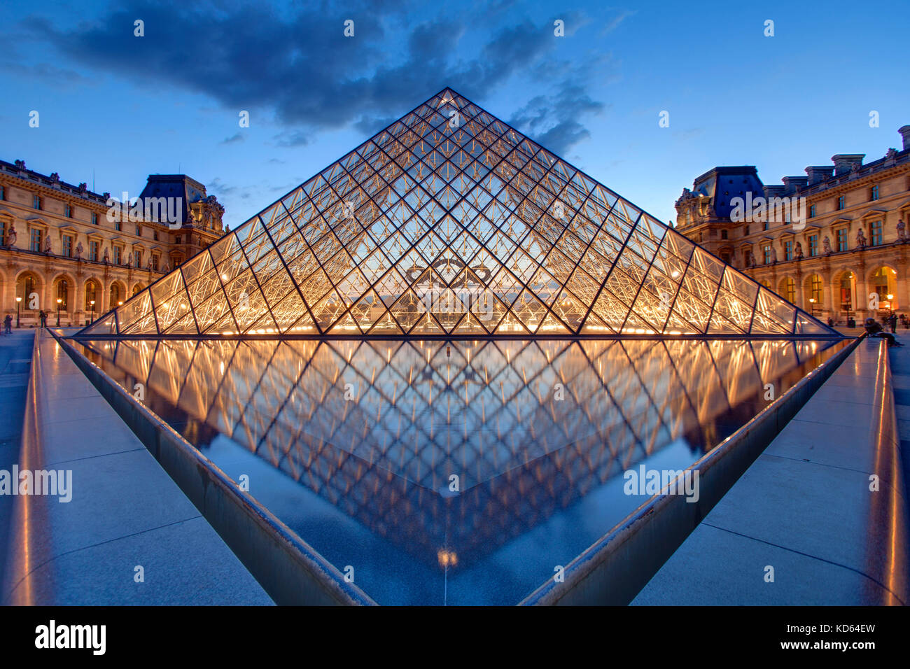 Paris (France): the Louvre Pyramid, a large glass and metal pyramid at the entrance to the museum, designed by architect I.M. Pei, here lit up at nigh Stock Photo